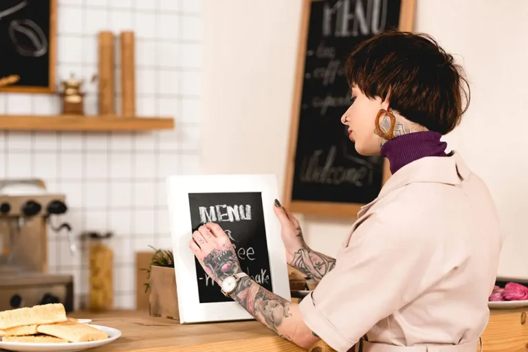 Mostrador de cafeter&iacute;a mostrando una pizarra de precios clara y profesional que cumple la normativa